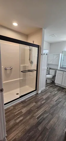 a bathroom with a granite countertop toilet sink and a mirror