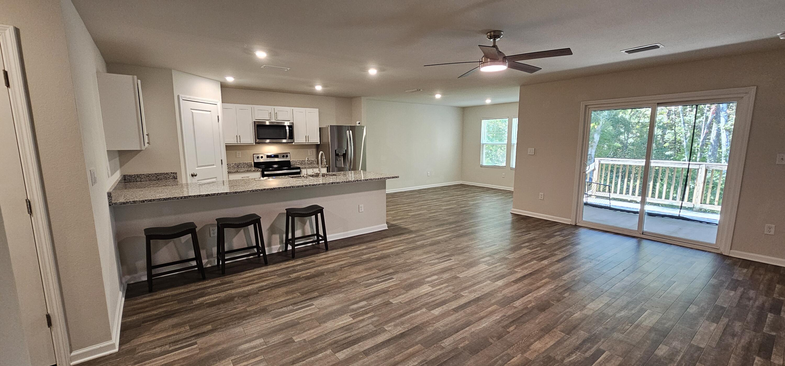460 Riverwalk Circle Freeport, FL 32439 - Photo 4 of 25 a kitchen with stainless steel appliances granite countertop a stove top oven a sink with wooden floors