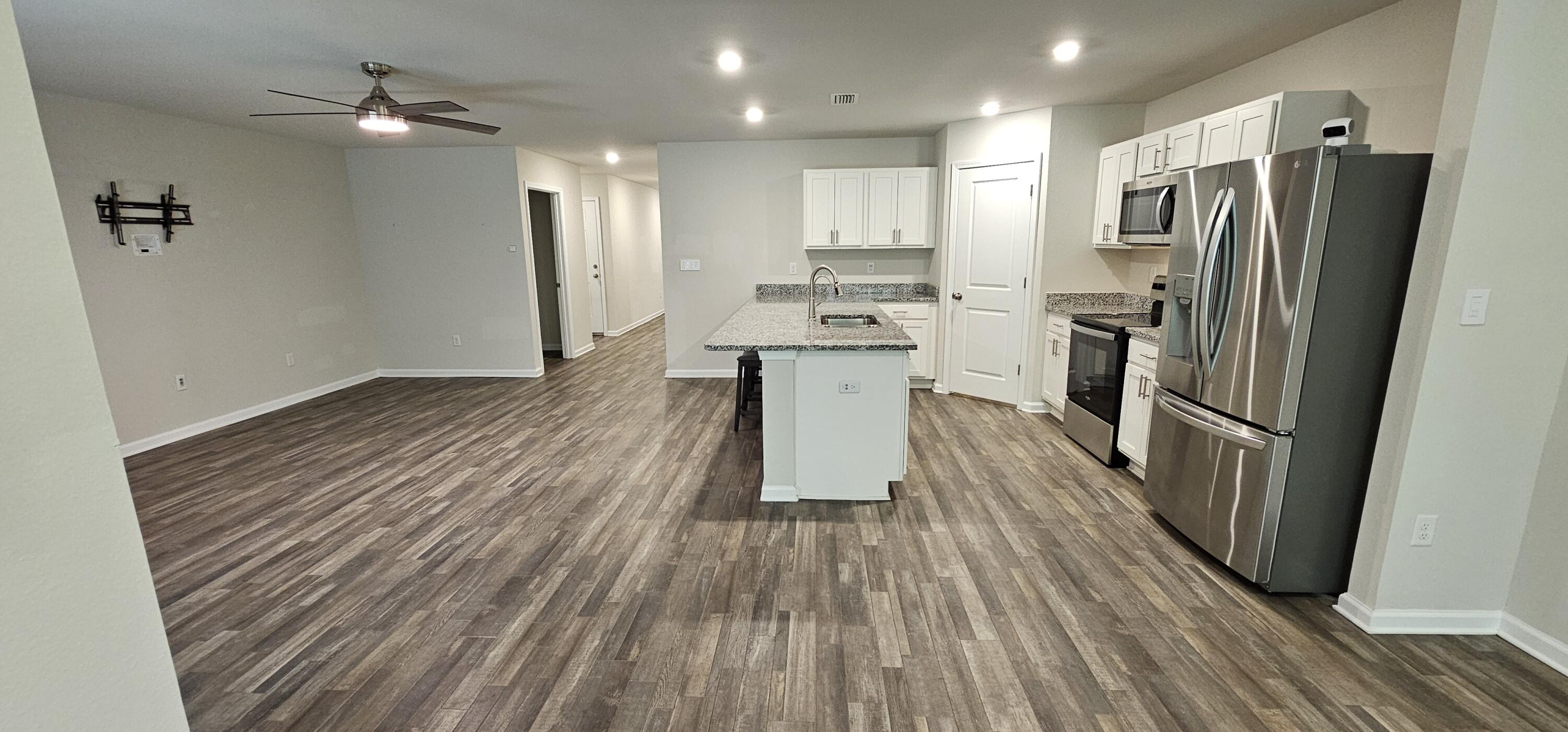 460 Riverwalk Circle Freeport, FL 32439 - Photo 6 of 25 a kitchen with kitchen island wooden floors appliances and cabinets