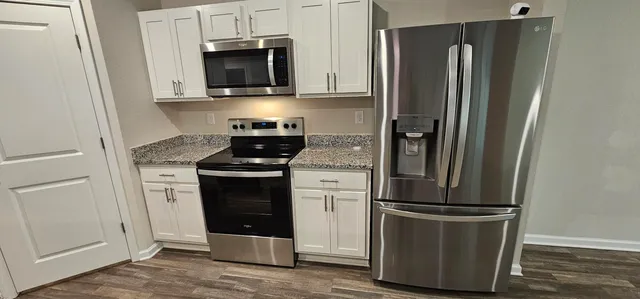 a kitchen with sink a refrigerator a stove and wooden floor