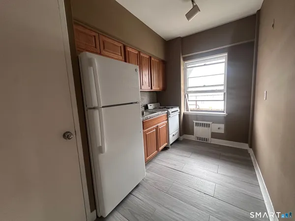 a white refrigerator freezer and a stove sitting inside of a kitchen