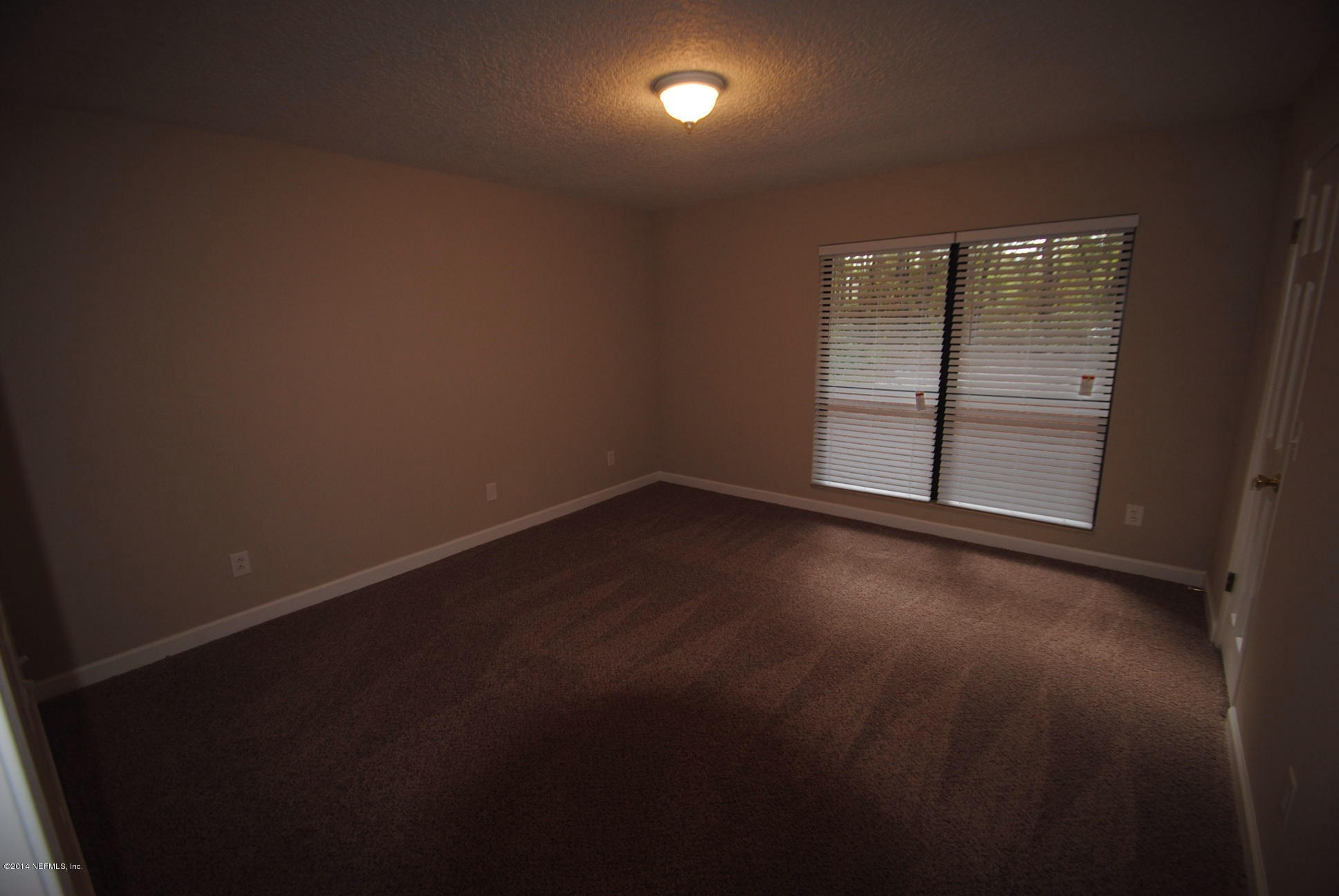11331 Scott Mill Road Jacksonville, FL 32223 - Photo 14 of 19 an empty room with wooden floor and windows