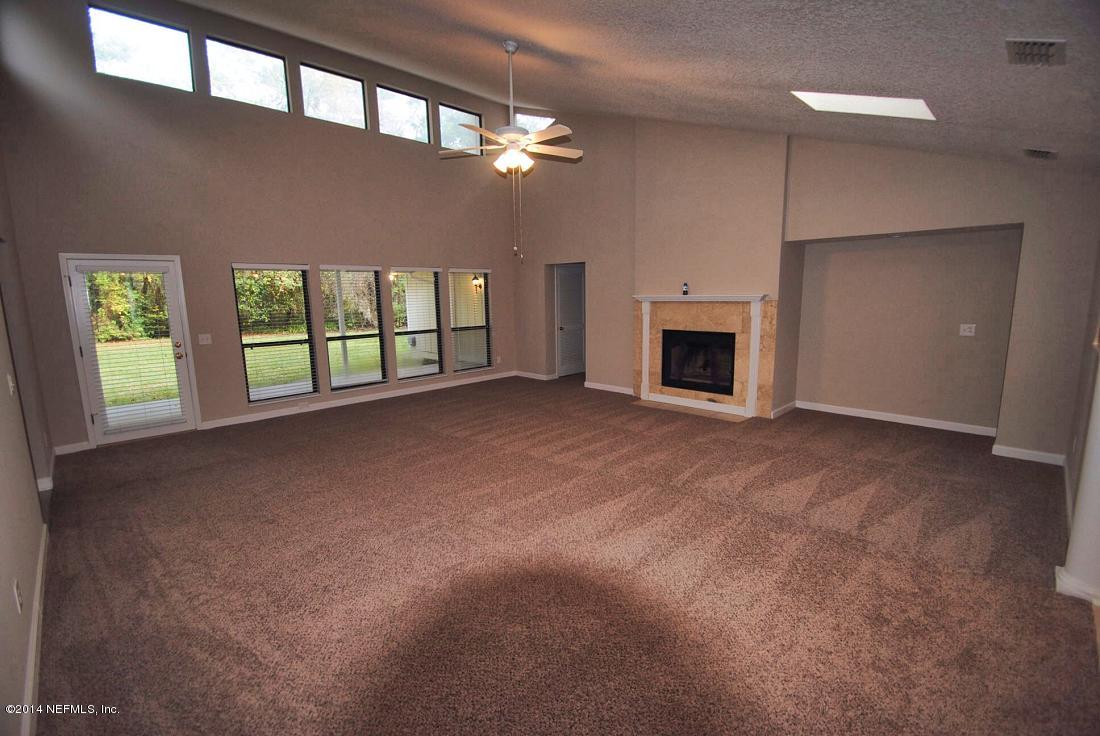 11331 Scott Mill Road Jacksonville, FL 32223 - Photo 3 of 19 a view of an empty room with a fireplace and a window