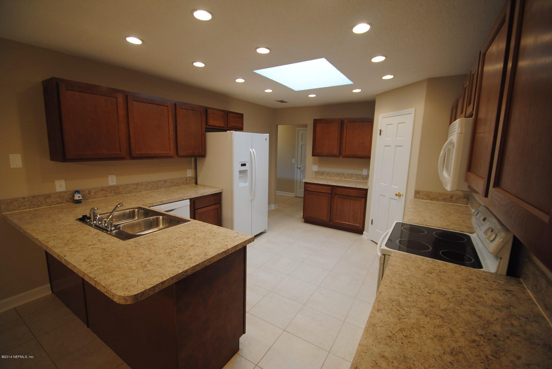 11331 Scott Mill Road Jacksonville, FL 32223 - Photo 7 of 19 a kitchen with granite countertop a refrigerator and a stove top oven