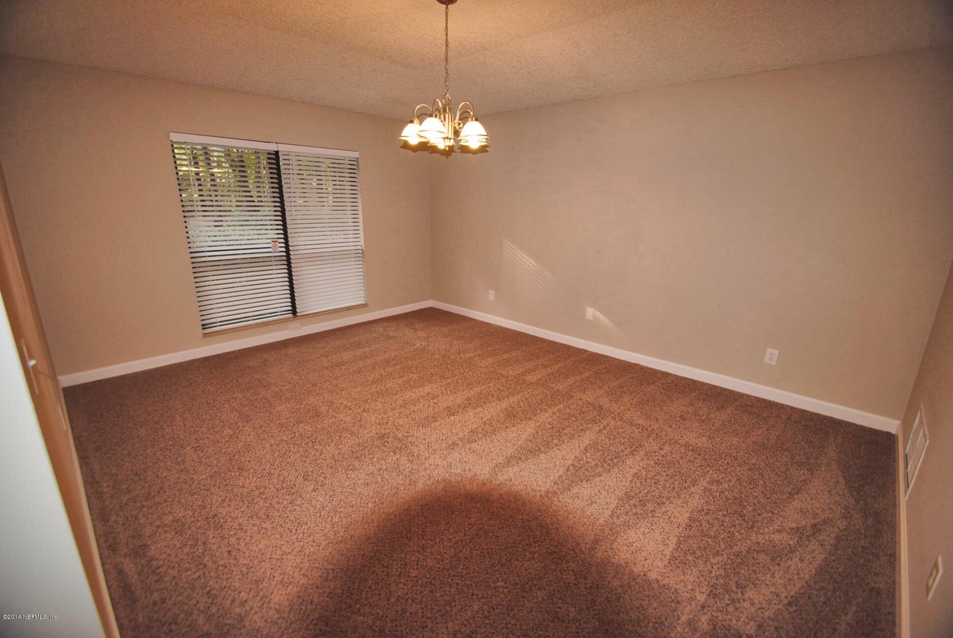 11331 Scott Mill Road Jacksonville, FL 32223 - Photo 9 of 19 a view of an empty room with window and chandelier fan