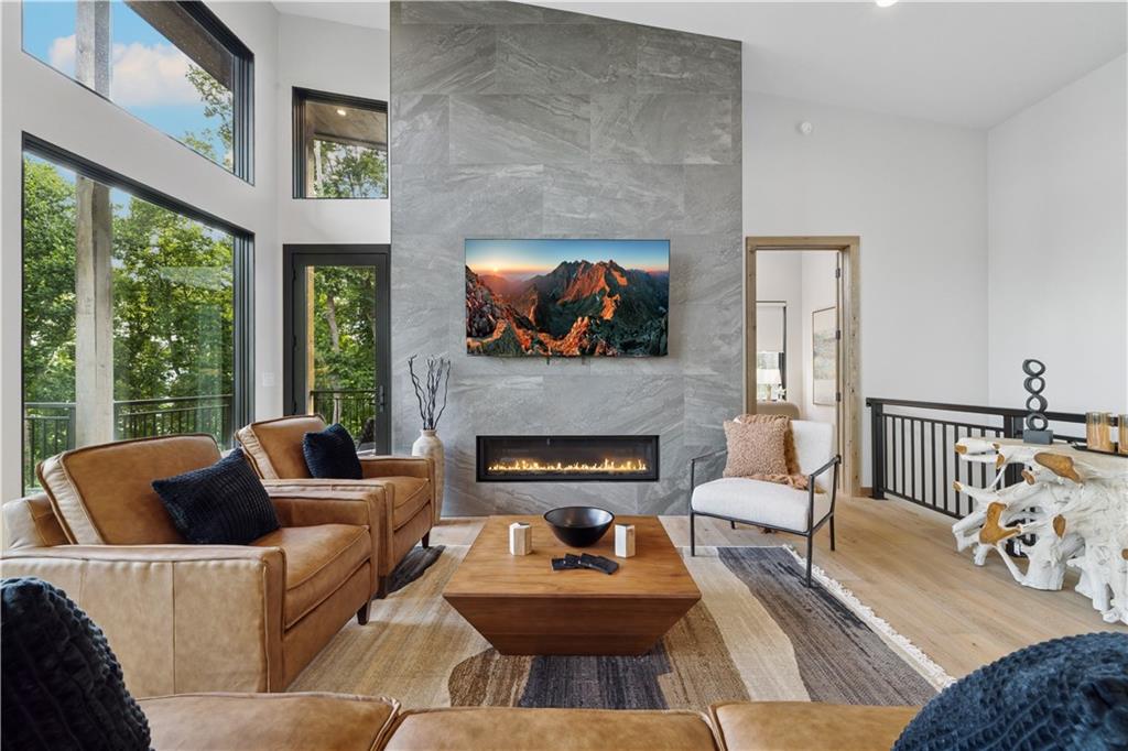 714 Scouts Overlook Lane Morganton, GA 30560 - Photo 16 of 48 a living room with furniture a fireplace and a floor to ceiling window
