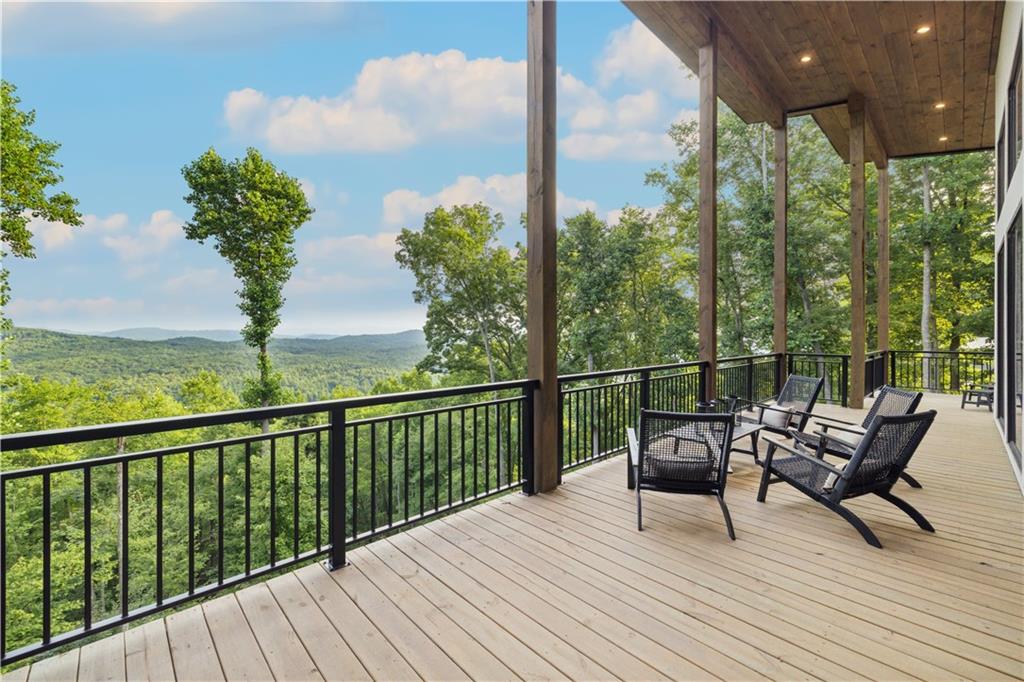 714 Scouts Overlook Lane Morganton, GA 30560 - Photo 17 of 48 a view of a balcony with wooden floor chairs and a table