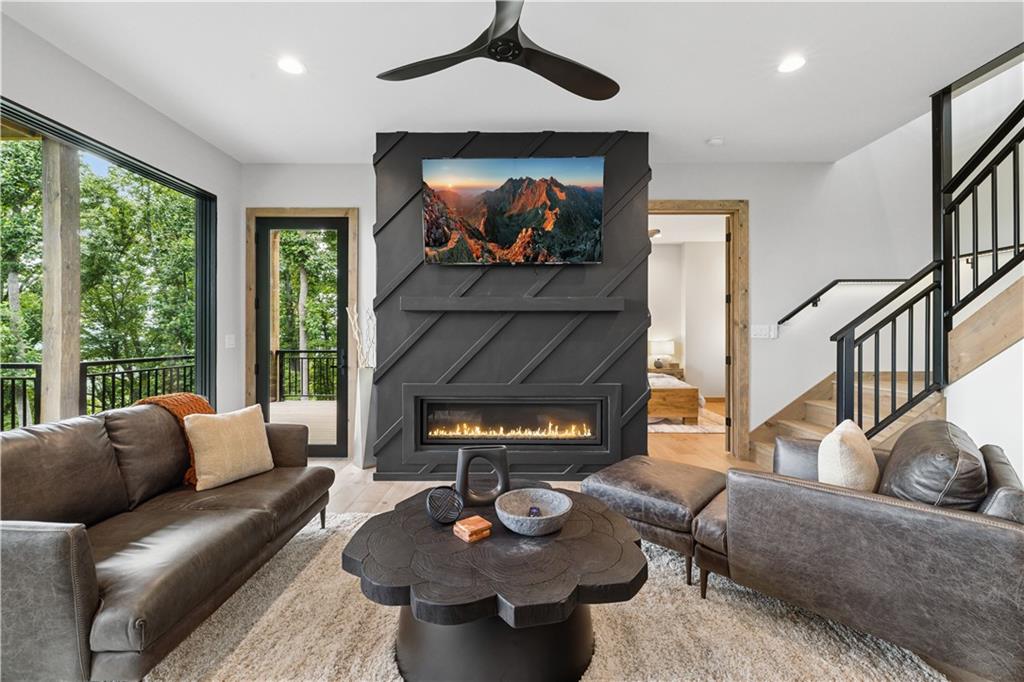 714 Scouts Overlook Lane Morganton, GA 30560 - Photo 29 of 48 a living room with furniture a fireplace and a floor to ceiling window