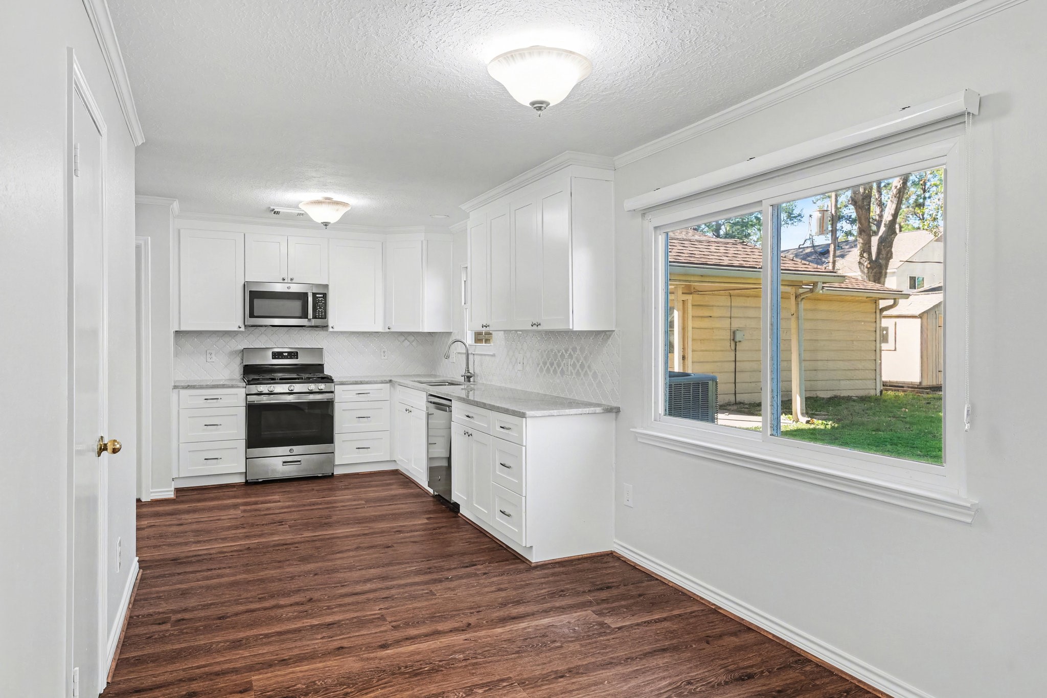 6910 Chancellor Drive Spring, TX 77379 - Photo 13 of 41 a kitchen with granite countertop wooden floors a sink and appliances