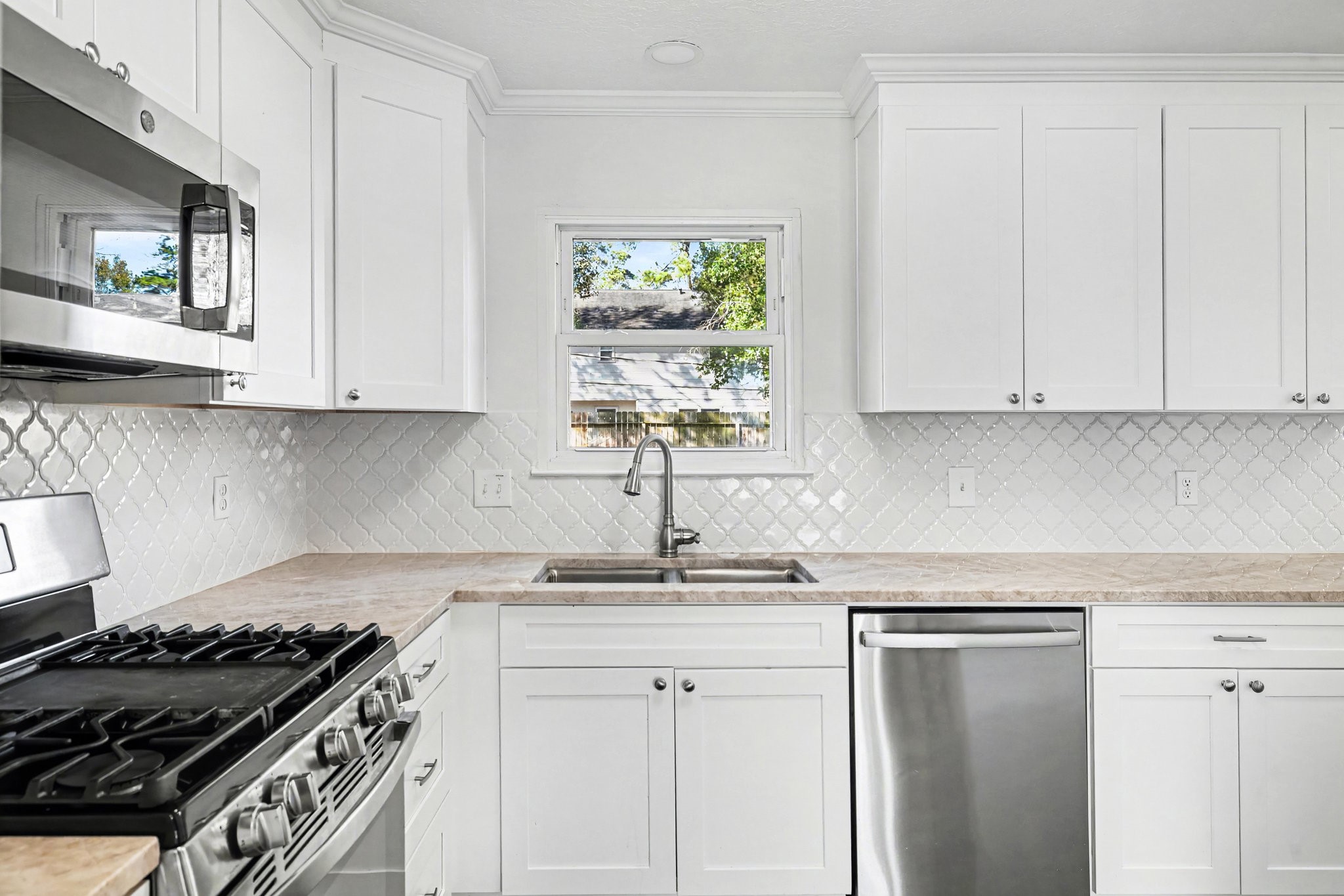 6910 Chancellor Drive Spring, TX 77379 - Photo 14 of 41 a kitchen with granite countertop white cabinets and window