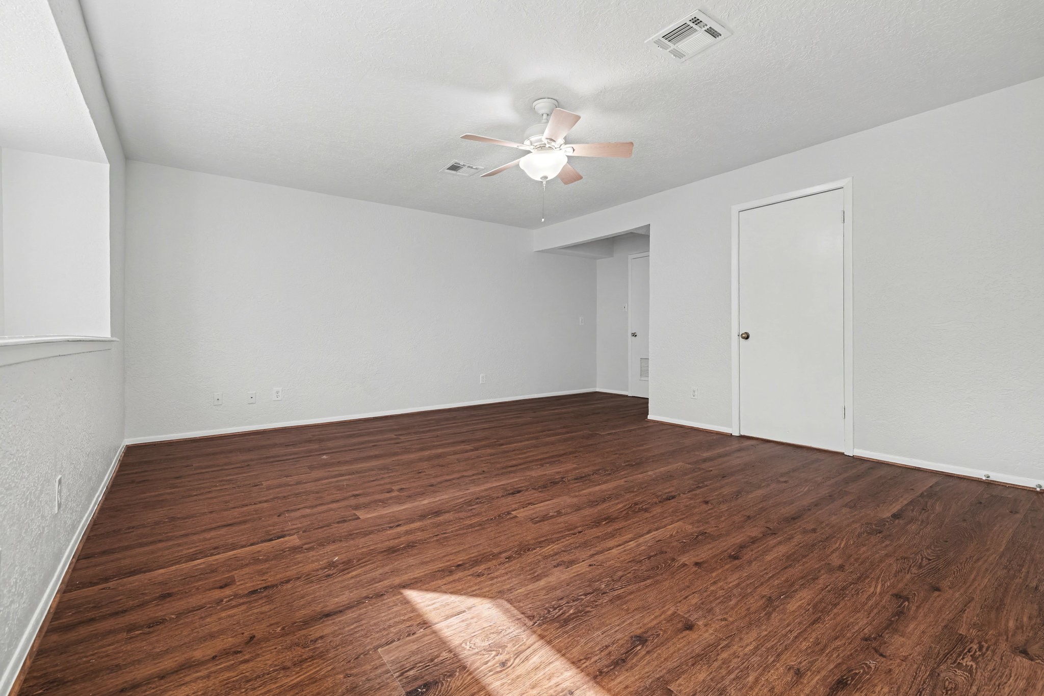6910 Chancellor Drive Spring, TX 77379 - Photo 17 of 41 a view of an empty room with wooden floor and a chandelier fan