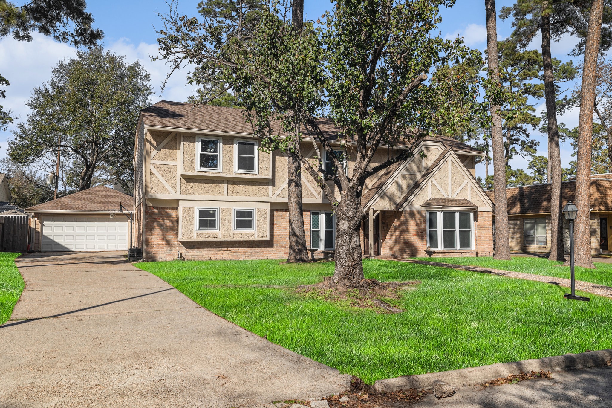 6910 Chancellor Drive Spring, TX 77379 - Photo 2 of 41 a front view of a house with a yard and trees