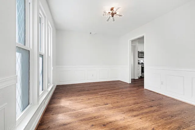 an empty room with wooden floor a fireplace and windows