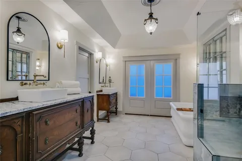 a spacious bathroom with a granite countertop sink a mirror and bathtub