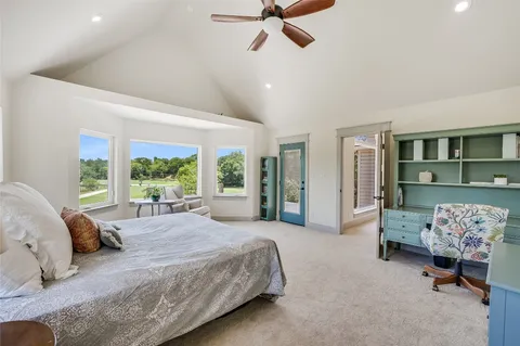 a spacious bedroom with a bed and a chandelier