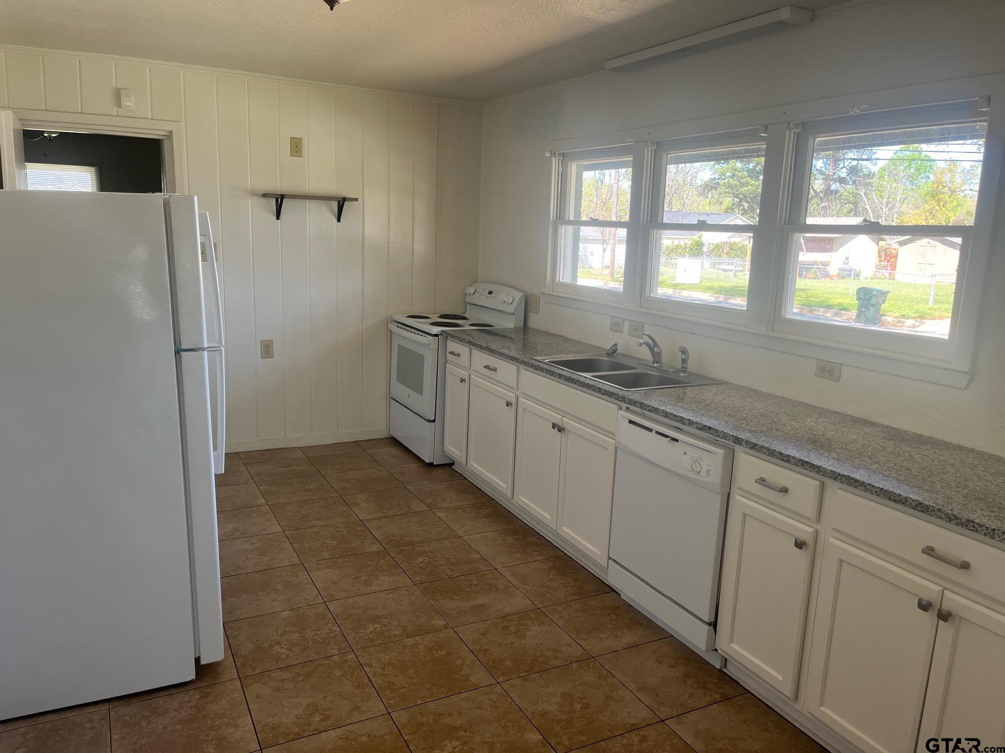 700 West 2nd Street Tyler, TX 75701 - Photo 9 of 10 a spacious bathroom with a granite countertop sink a mirror and a bathtub