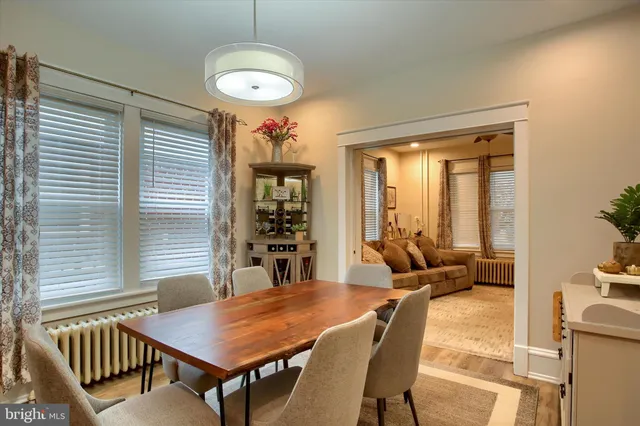 a kitchen with stainless steel appliances granite countertop a table chairs sink and window