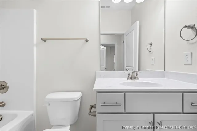 a bathroom with a sink toilet vanity and tub