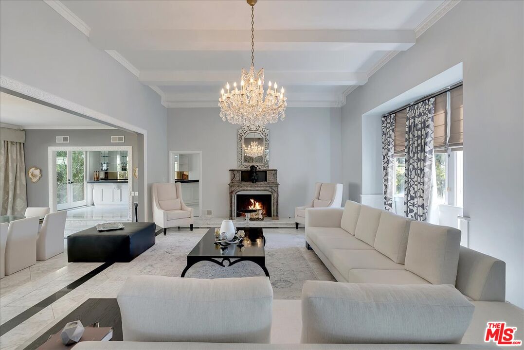 a living room with furniture chandelier and a fireplace