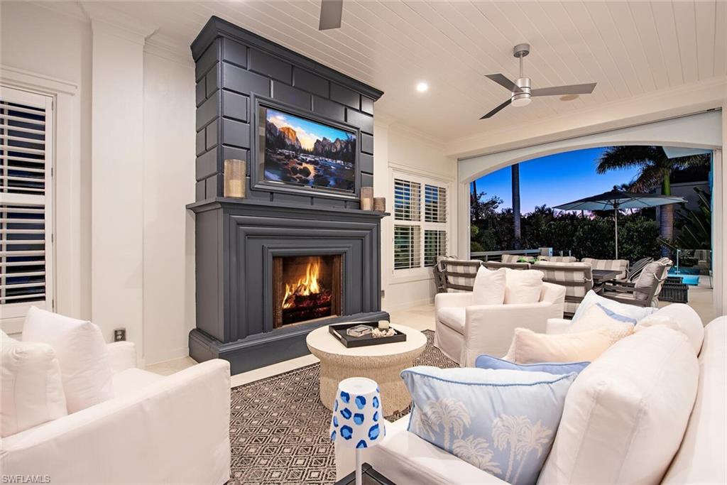 140 3rd Avenue South Naples, FL 34102 - Photo 19 of 46 a living room with furniture a fireplace and a ceiling fan