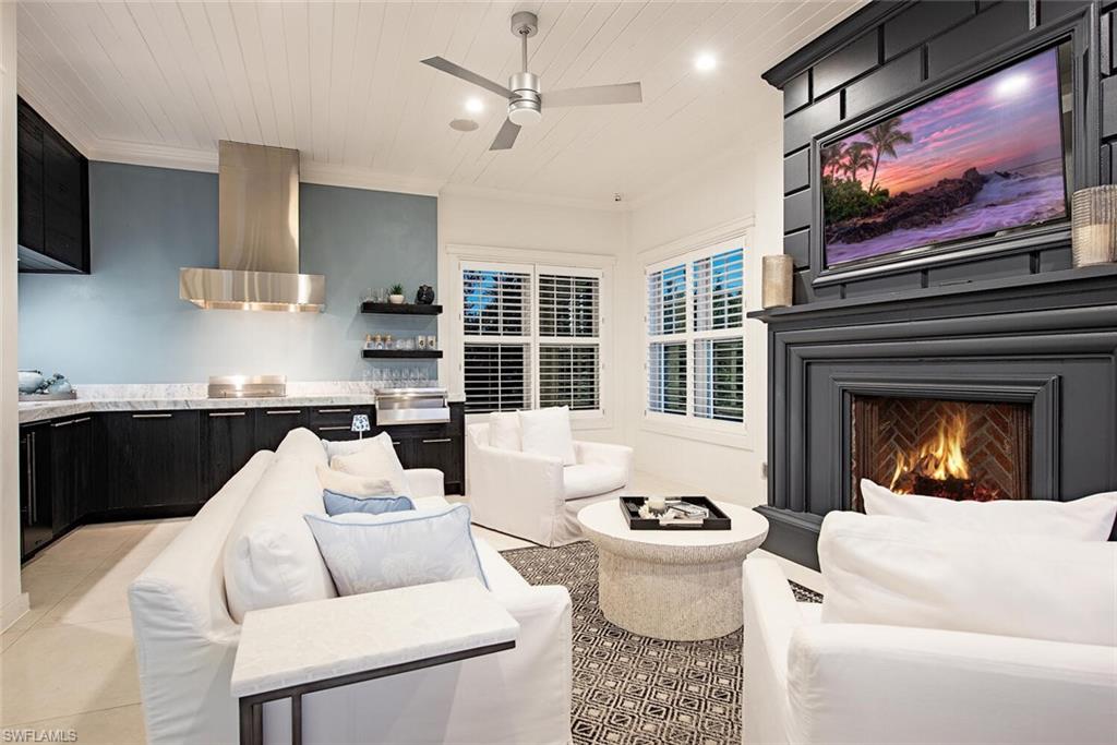 140 3rd Avenue South Naples, FL 34102 - Photo 20 of 46 a living room with furniture a flat screen tv and a fireplace