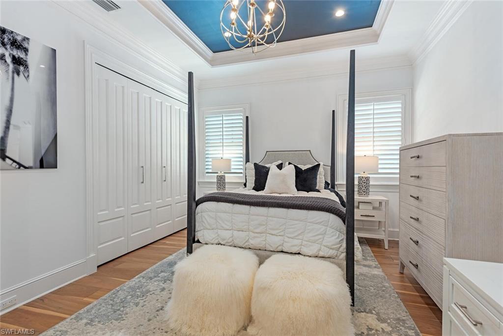 140 3rd Avenue South Naples, FL 34102 - Photo 33 of 46 a bedroom with a bed and a chandelier