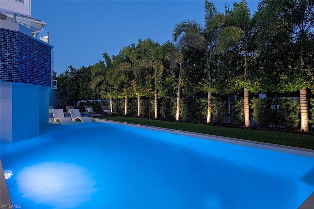 140 3rd Avenue South Naples, FL 34102 - Photo 40 of 46 a view of swimming pool with outdoor seating and trees in the background