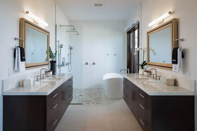 a bathroom with a double vanity sink mirror double and bathtub