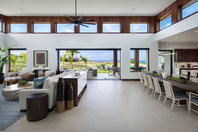 a hall way with furniture a rug and a chandelier