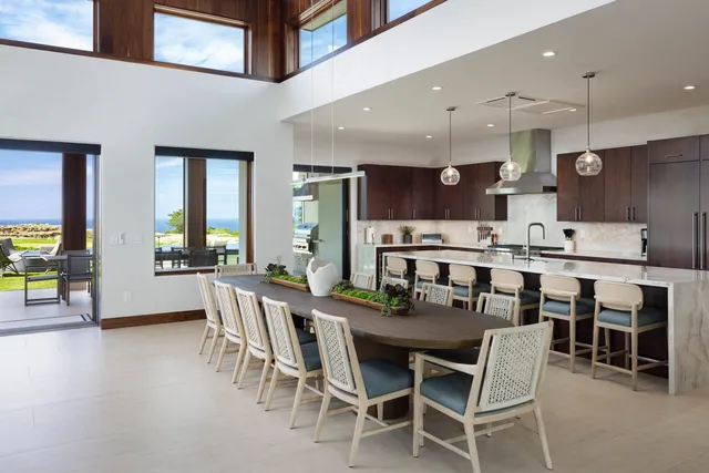 a dining area with stainless steel appliances kitchen island granite countertop a dining table chairs and view living room