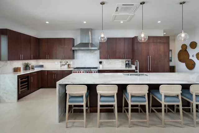 a kitchen with a dining table chairs and wooden cabinets