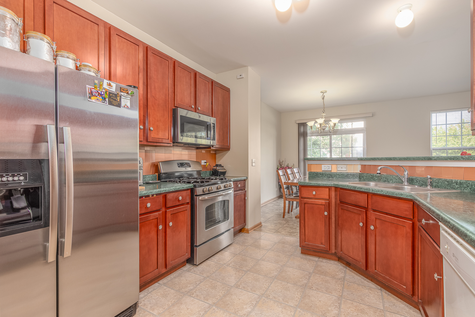 1902 Crestview Circle, Unit 1902 Romeoville, IL 60446 - Photo 14 of 32 a large kitchen with stainless steel appliances granite countertop a stove a sink dishwasher a refrigerator and a microwave oven