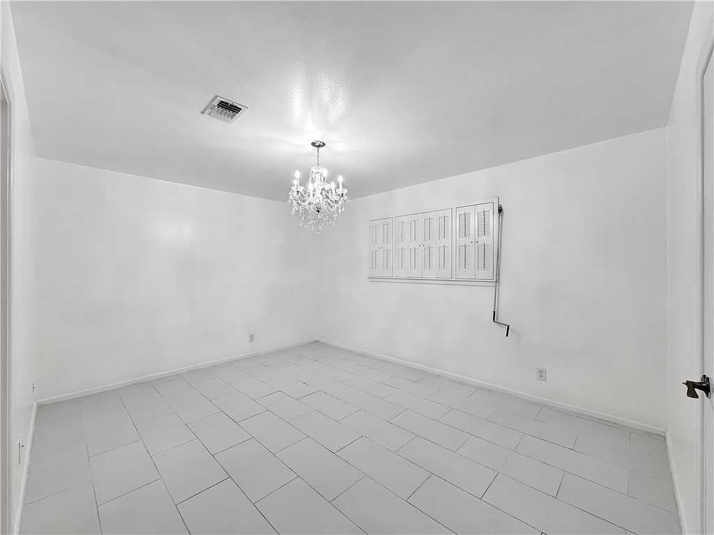 4115 Meridian Place Corpus Christi, TX 78411 - Photo 12 of 24 an empty room with chandelier fan and windows