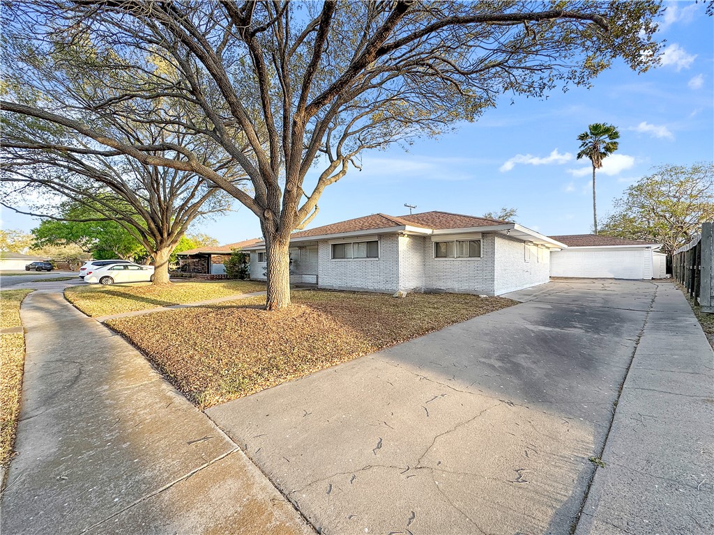 4115 Meridian Place Corpus Christi, TX 78411 - Photo 2 of 24 a front view of a house with a yard and trees