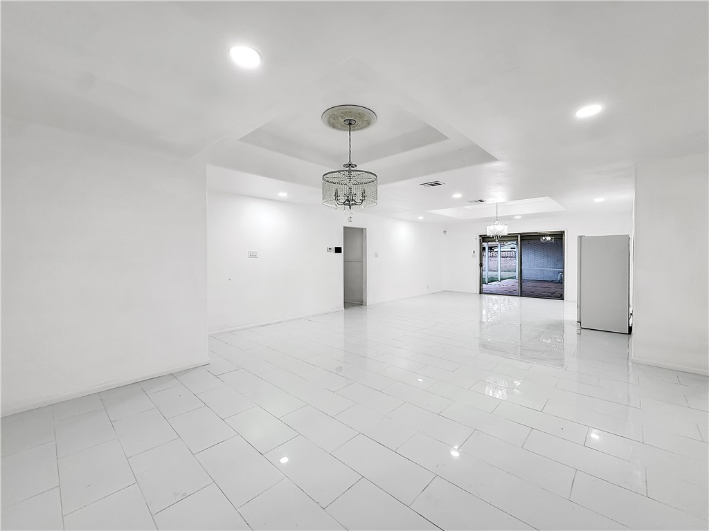 4115 Meridian Place Corpus Christi, TX 78411 - Photo 6 of 24 an empty room with kitchen view and a chandelier