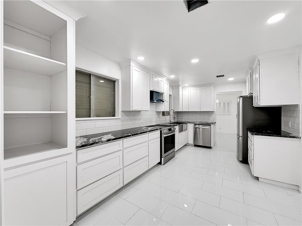 4115 Meridian Place Corpus Christi, TX 78411 - Photo 8 of 24 a large white kitchen with stainless steel appliances granite countertop a stove and a sink