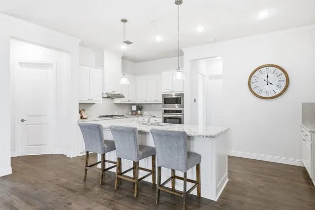 a kitchen with a dining table a sink and cabinets