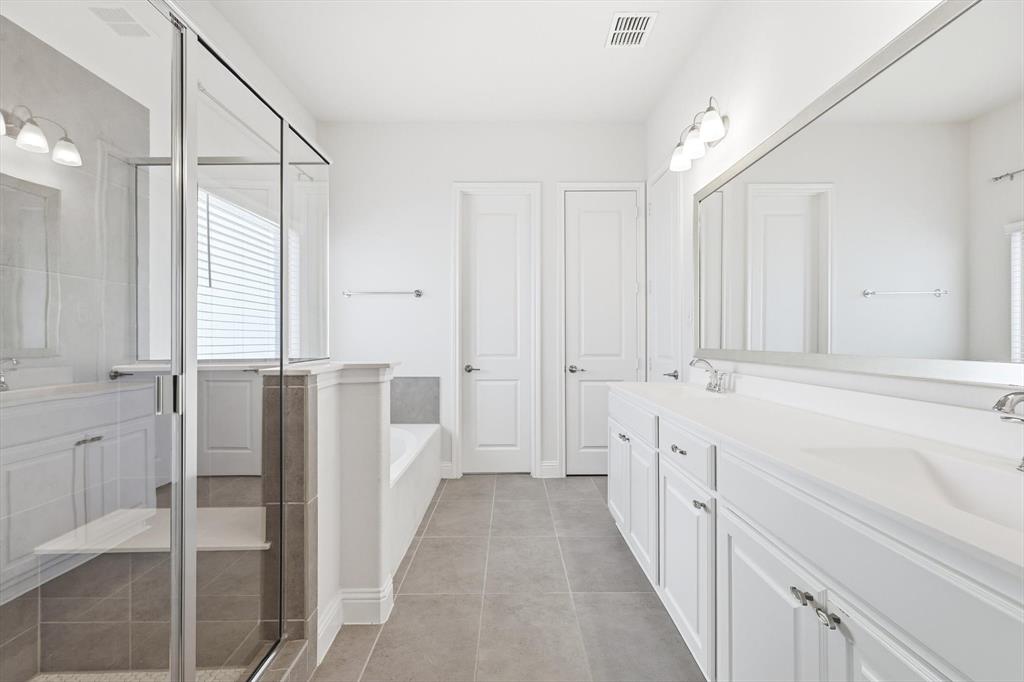 5409 Welsh Street Denton, TX 76226 - Photo 18 of 31 Full ensuite bathroom with a garden tub, double vanity with lots of storage, a tile shower stall, and light tile patterned floors.