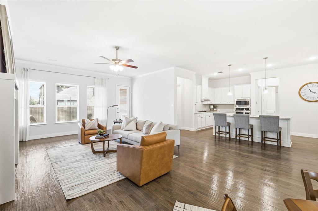 5409 Welsh Street Denton, TX 76226 - Photo 4 of 31 Living area with crown molding, dark nail down hardwood finished floors and recessed lighting.