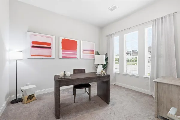 a view of a workspace with furniture and a window