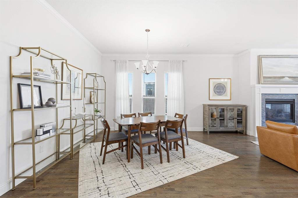5409 Welsh Street Denton, TX 76226 - Photo 7 of 31 Spacious dining area with crown molding, dark hardwood flooring and a chandelier.