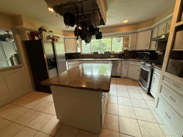 a kitchen with stainless steel appliances granite countertop a sink a counter top space cabinets and stainless steel appliances