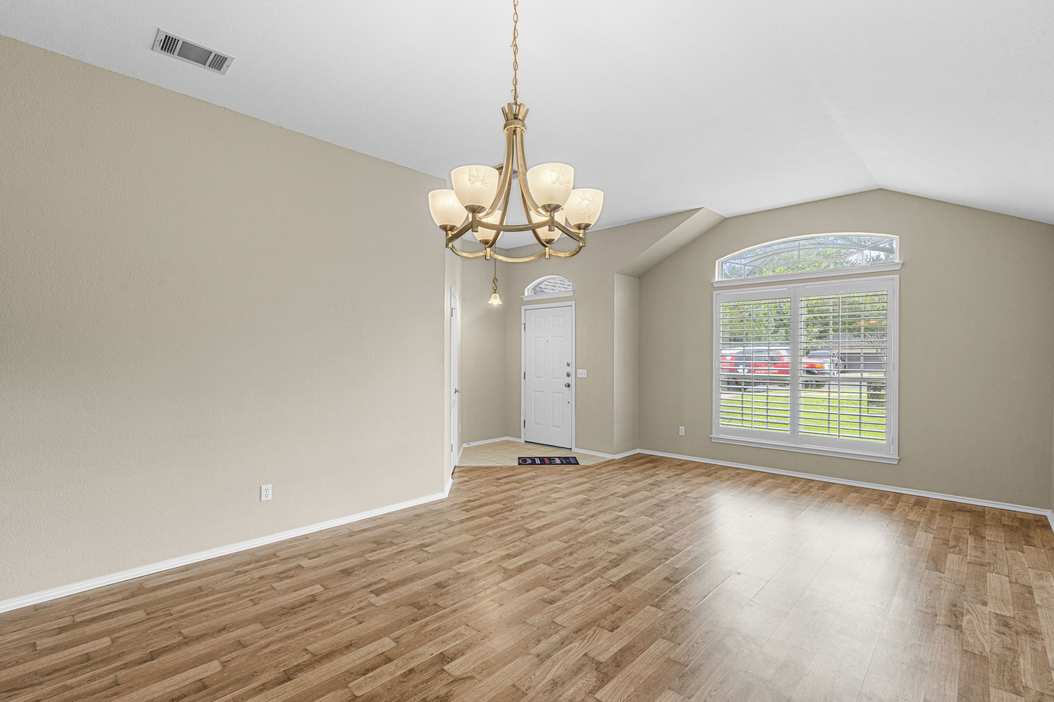 7172 Ridge Oak Road Austin, TX 78749 - Photo 17 of 40 Step into this spacious living area, complete with durable laminate flooring and a captivating arched window.