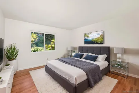 a bedroom with a bed and a painting on the wall