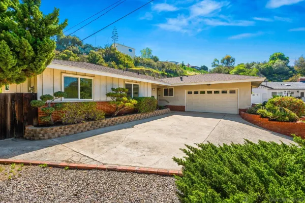 a front view of a house with a yard and potted plants