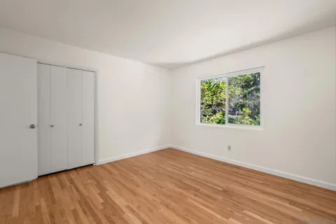 a view of empty room with wooden floor