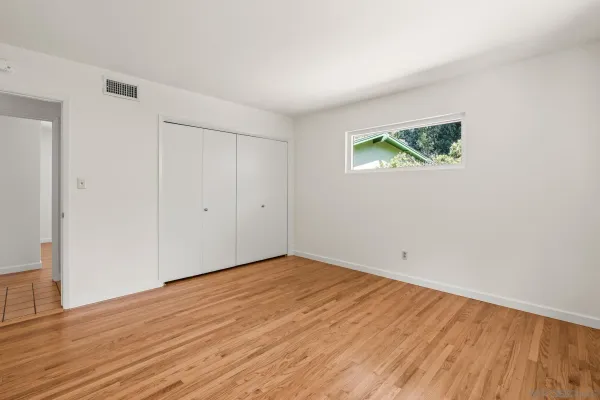 a view of an empty room with wooden floor