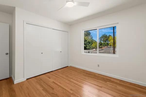 a view of empty room with wooden floor