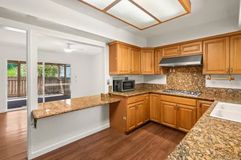 a large kitchen with granite countertop a large window and stainless steel appliances
