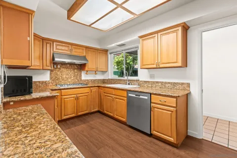 a kitchen with stainless steel appliances granite countertop a stove a sink and a microwave